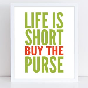 May include: A white framed print with the text "Life is short buy the purse" in green and red letters.