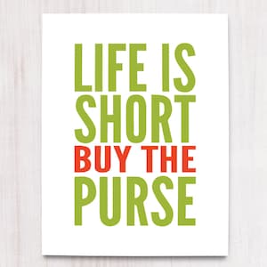 May include: A white card with the text "Life is short buy the purse" in green and orange letters.