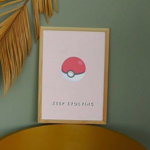 May include: A framed print with a pink background featuring a red and white Pokeball with the text "KEEP EVOLVING" in white.
