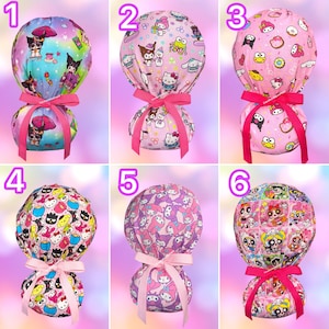 May include: Six scrub caps featuring various Sanrio character prints including Hello Kitty, Kuromi, and My Melody. Each cap has a rounded top, a gathered back, and a bright pink or light pink ribbon tied in a bow at the base to secure the fabric.
