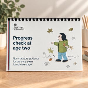 May include: A white spiral-bound booklet titled Progress check at age two, Non-statutory guidance for the early years foundation stage, featuring a Department for Education logo and an illustration of a child in a green jacket playing with leaves.
