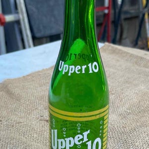 元々 Nehi Corporation が製造していたレモンライム風味のソフトドリンク、Upper 10 用のビンテージの緑色のガラス製ソーダボトル。