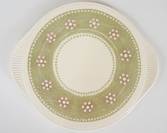 May include: A white ceramic serving platter with a green and pink floral design. The platter has two handles on the sides.