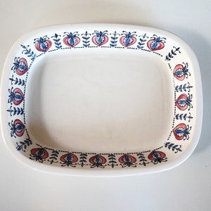 Może przedstawiać: Biała ceramiczna tacka do serwowania o prostokątnym kształcie z niebiesko-czerwonym kwiatowym obramowaniem. Taca idealnie nadaje się do serwowania przekąsek, deserów lub przystawek.