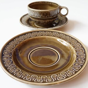 May include: A set of green ceramic teacups and saucers with a white paisley design. The cups and saucers have a glossy finish.