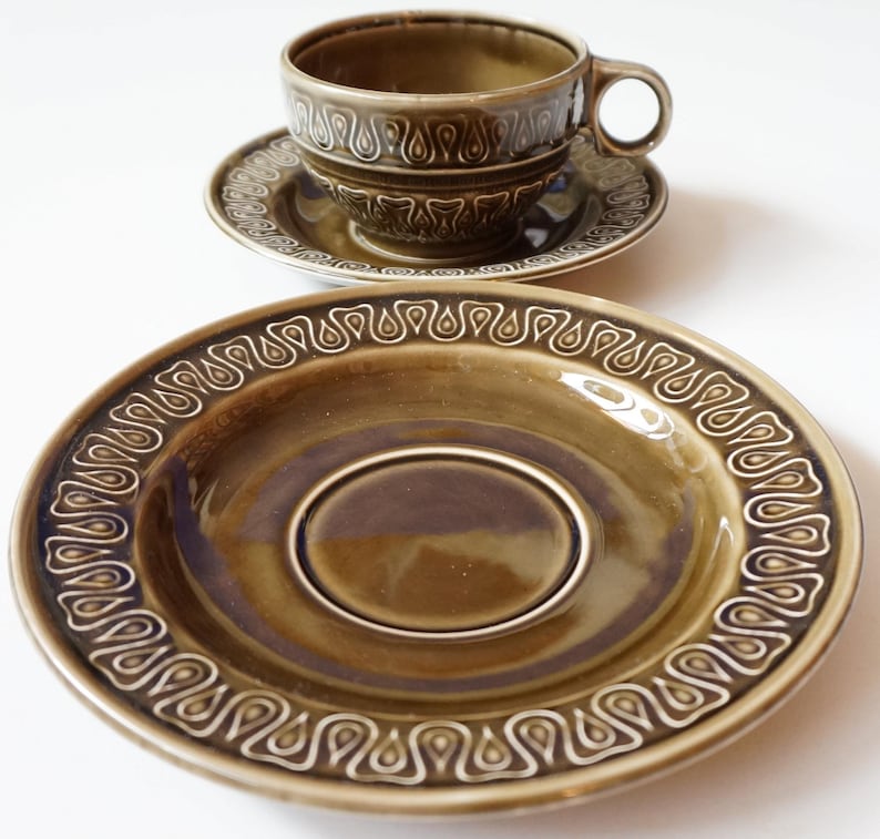 May include: A set of green ceramic teacups and saucers with a white paisley design. The cups and saucers have a glossy finish.