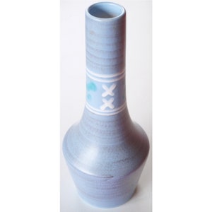 May include: A light blue ceramic vase with a white and blue design. The vase has a narrow neck and a wide base.