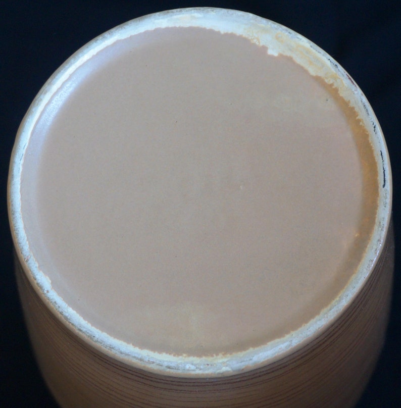 Puede incluir: Un tarro de cer&aacute;mica marr&oacute;n con un borde blanco y un patr&oacute;n acanalado. El tarro est&aacute; vac&iacute;o y la parte superior es visible.