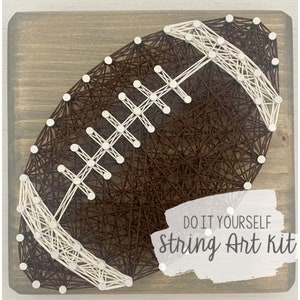 May include: DIY string art kit featuring a brown football with white stitching. The kit includes all the materials needed to create the artwork.  "DO IT YOURSELF String Art Kit" is written on the wood.