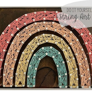 May include: DIY String Art Kit featuring a rainbow design on a wooden base. The rainbow is made of colorful string wrapped around nails.