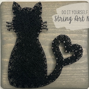 Puede incluir: Kit de arte de hilo para hacer tú mismo con un gato negro con cola en forma de corazón. El kit incluye todos los materiales necesarios para crear la obra de arte, incluyendo una base de madera, clavos e hilo.