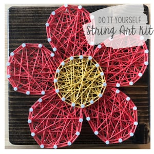 May include: DIY string art kit featuring a red flower with a yellow center. The flower is made of string wrapped around nails on a wooden board.