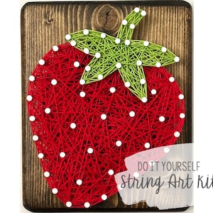 May include: DIY string art kit featuring a red strawberry with green leaves. The kit includes all the materials needed to create the artwork.