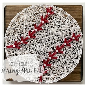 May include: DIY string art kit featuring a baseball design with red stitching on a white background. The baseball is mounted on a wooden plaque.