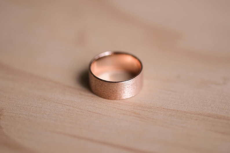 May include: A rose gold ring with a brushed finish.