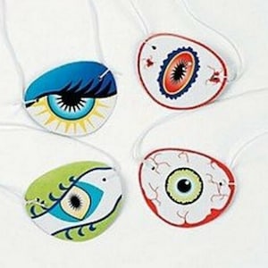 May include: Four colourful eye patch designs with white string attached. The eye patches feature different designs, including a blue eye with eyelashes, a green eye with veins, a red eye with a black pupil, and a green eye with a blue iris.