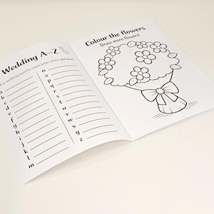 May include: An open activity book with black and white printed pages. The left page features a Wedding A-Z list with lines for writing. The right page shows a line art illustration of a flower bouquet with the text Colour the flowers. Draw more flowers!