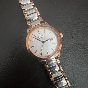 Reloj de pulsera giratorio de acero inoxidable y oro.