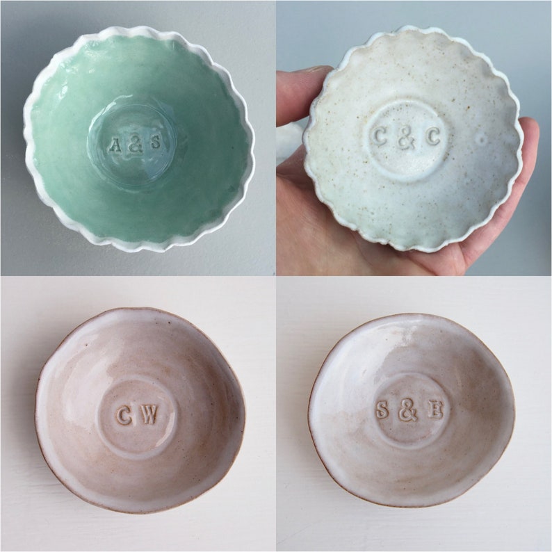 May include: Four ceramic ring dishes with scalloped edges. The dishes are in various colors, including green, white, and beige. Each dish has a different set of initials in the center, including A&S, C&C, CW, and S&B.