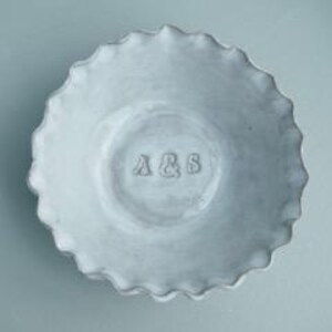 May include: White ceramic bowl with a scalloped edge and the initials "A & S" embossed on the bottom.