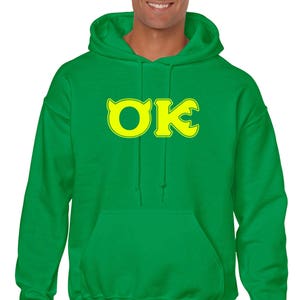 May include: Green hooded sweatshirt with a yellow "OK" logo on the front.