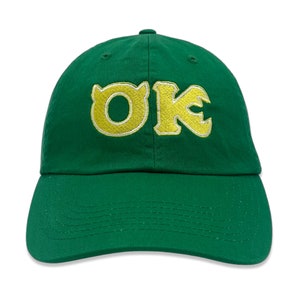May include: Green baseball cap with a yellow embroidered "OK" logo.