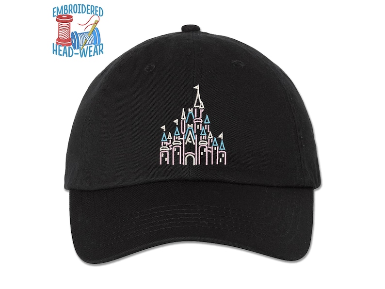Pode incluir: Bon&eacute; de beisebol preto com um contorno bordado do castelo da Cinderela em rosa, azul e branco. O texto "EMBROIDERED HEAD-WEAR" est&aacute; acima do castelo.