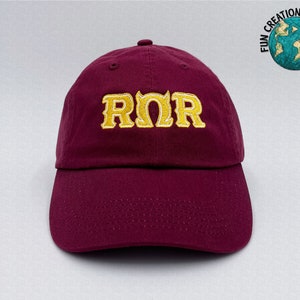 May include: Burgundy baseball cap with a gold embroidered "RMR" logo.