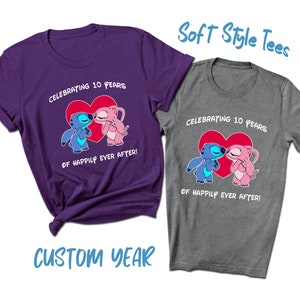 May include: Two soft style t-shirts with a blue and pink cartoon couple kissing in front of a red heart. The text on the shirts reads "Celebrating 10 years of happily ever after!"