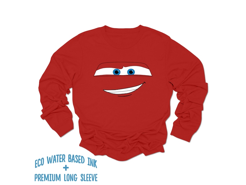 May include: Red long-sleeve shirt with a cartoon face of a red race car with blue eyes and a smile. The shirt has the text "ECO WATER BASED INK + PREMIUM LONG SLEEVE" printed on the bottom.
