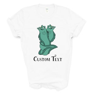 May include: White t-shirt with a green cartoon image of two eels with yellow eyes and the text "CUSTOM TEXT" printed below the image.