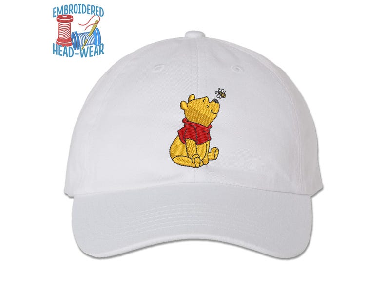 May include: White baseball cap with an embroidered image of Winnie the Pooh sitting and looking at a bee.