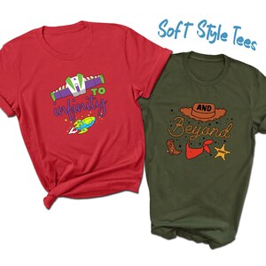 May include: Two short-sleeved t-shirts. One is red with a graphic of a spaceship and the words "to infinity". The other is olive green with a cowboy hat graphic and the words "and beyond". The text "Soft Style Tees" is also visible.