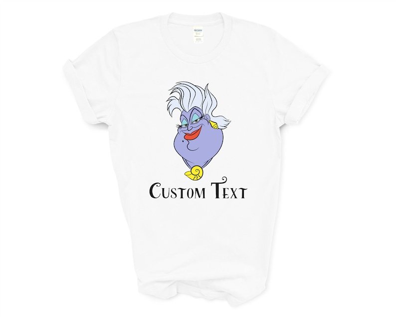 May include: White t-shirt with a purple cartoon image of Ursula from The Little Mermaid. The text "CUSTOM TEXT" is printed below the image.