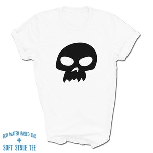 Pu&ograve; includere: Maglietta bianca con una grafica di teschio nero. Il testo "ECO WATER BASED INK + SOFT STYLE TEE" &egrave; stampato sul fondo della maglietta.