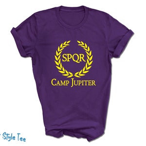 May include: Purple t-shirt with a yellow laurel wreath and the text "SPQR CAMP JUPITER"