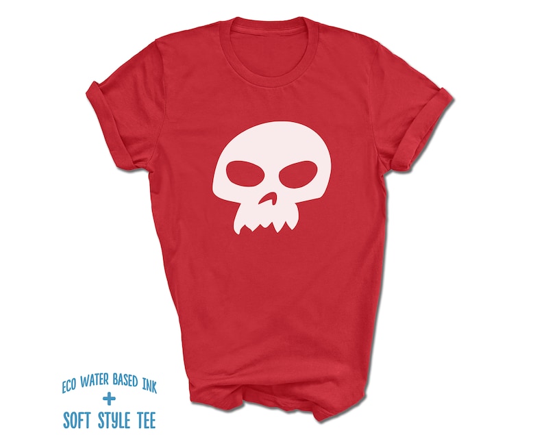 Pu&ograve; includere: Maglietta rossa con una grafica di teschio bianco. Il teschio ha un design semplice con due orbite e una piccola bocca.