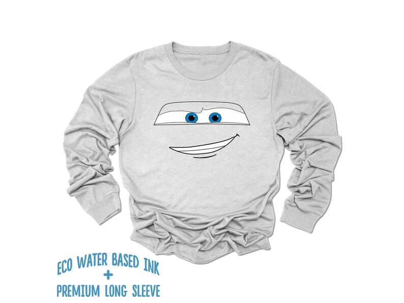 May include: A gray long-sleeve t-shirt with a black and white outline of a cartoon face with blue eyes. The text "ECO WATER BASED INK + PREMIUM LONG SLEEVE" is printed below the image.