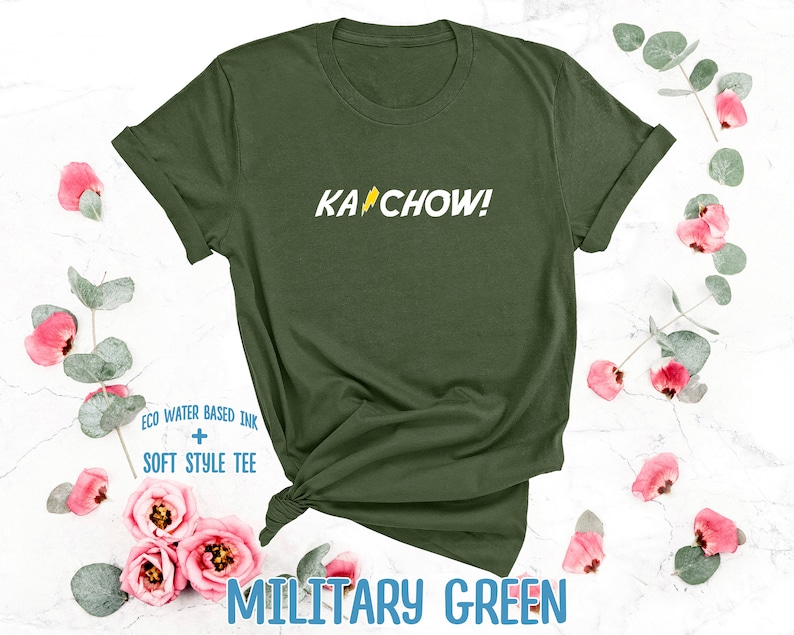 Op de afbeelding: Een groen T-shirt met de tekst "KACHOW!" in het geel gedrukt op de voorkant. Het shirt is gemaakt met milieuvriendelijke, watergebaseerde inkt en heeft een zacht, comfortabel gevoel.