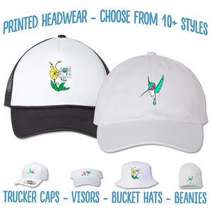 May include: A selection of printed headwear, including trucker caps, visors, bucket hats, and beanies. The headwear features a variety of designs, including a hummingbird and a flower.