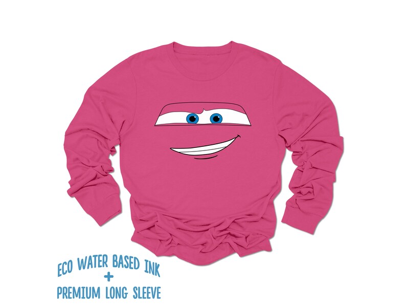 May include: Pink long-sleeved shirt with a cartoon face of a red car with blue eyes and a smile. The shirt has the text "ECO WATER BASED INK + PREMIUM LONG SLEEVE" printed on the bottom.
