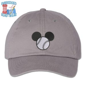 May include: A gray baseball cap with an embroidered design of Mickey Mouse holding a baseball. The baseball is white with black stitching.
