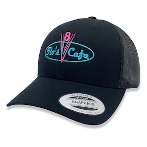 May include: Black trucker hat with a pink and blue embroidered logo that says "Flo's V Cafe" and the number "8". The hat has a black mesh back and a black snap closure.