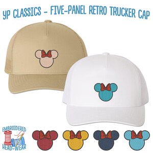 May include: Two five-panel trucker caps with embroidered Mickey Mouse ears and a red bow. The caps are beige and white. The text "YP CLASSICS - FIVE-PANEL RETRO TRUCKER CAP" is at the top of the image. Below the caps are five embroidered Mickey Mouse ears with different colored bows: red, yellow, blue, navy blue, and turquoise.