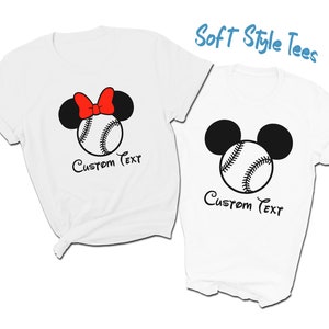 May include: Two white t-shirts with a baseball and Mickey Mouse ears design. The shirt on the left has a red bow on the ears. Both shirts have the text "Custom Text" printed below the design.