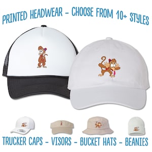 May include: A selection of printed headwear featuring a cartoon monkey design. The headwear includes trucker caps, visors, bucket hats, and beanies.  "PRINTED HEADWEAR - CHOOSE FROM 10+ STYLES" and "TRUCKER CAPS - VISORS - BUCKET HATS - BEANIES" are printed at the top and bottom of the image.