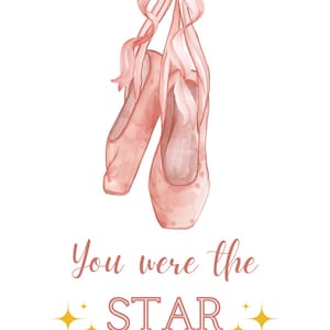 May include: Pink ballet shoes with a pink ribbon bow. The text "You were the STAR of the show!" is written below the shoes. The text "MORGAN + GARRETT" is written below the text.