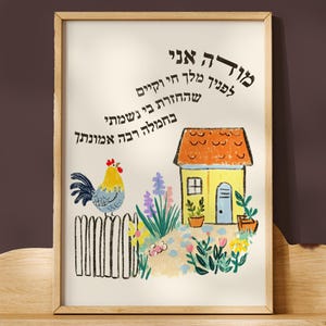 May include: A framed art print featuring a colorful illustration of a house, rooster, and flowers. The artwork is displayed on a cloud-shaped wooden shelf. The print has text in Hebrew. The color palette includes yellow, orange, blue, and green.