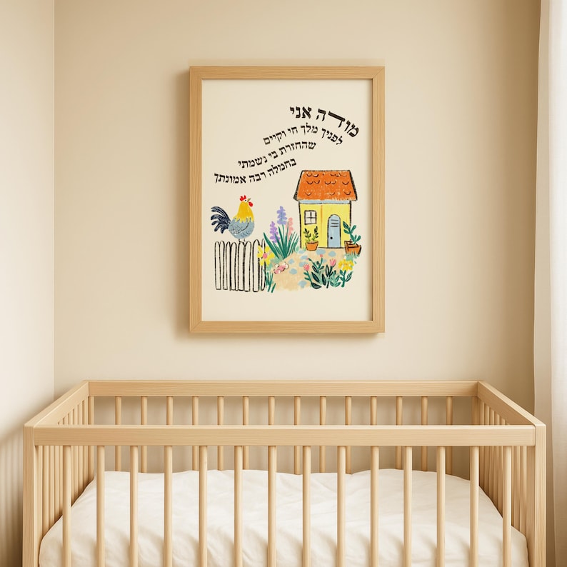 May include: A framed print with a whimsical illustration of a house, rooster, and garden. The artwork features a yellow house with a brown roof, a blue door, and a colorful garden. The text in the image is in Hebrew.
