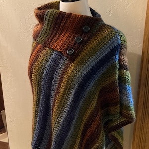 May include: A striped crocheted poncho with a high collar and three buttons. The poncho is made in shades of brown, green, blue, and gray.